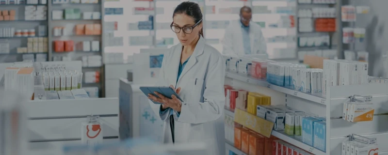 uma farmaceutica dentro da farmácia usando um tablet
