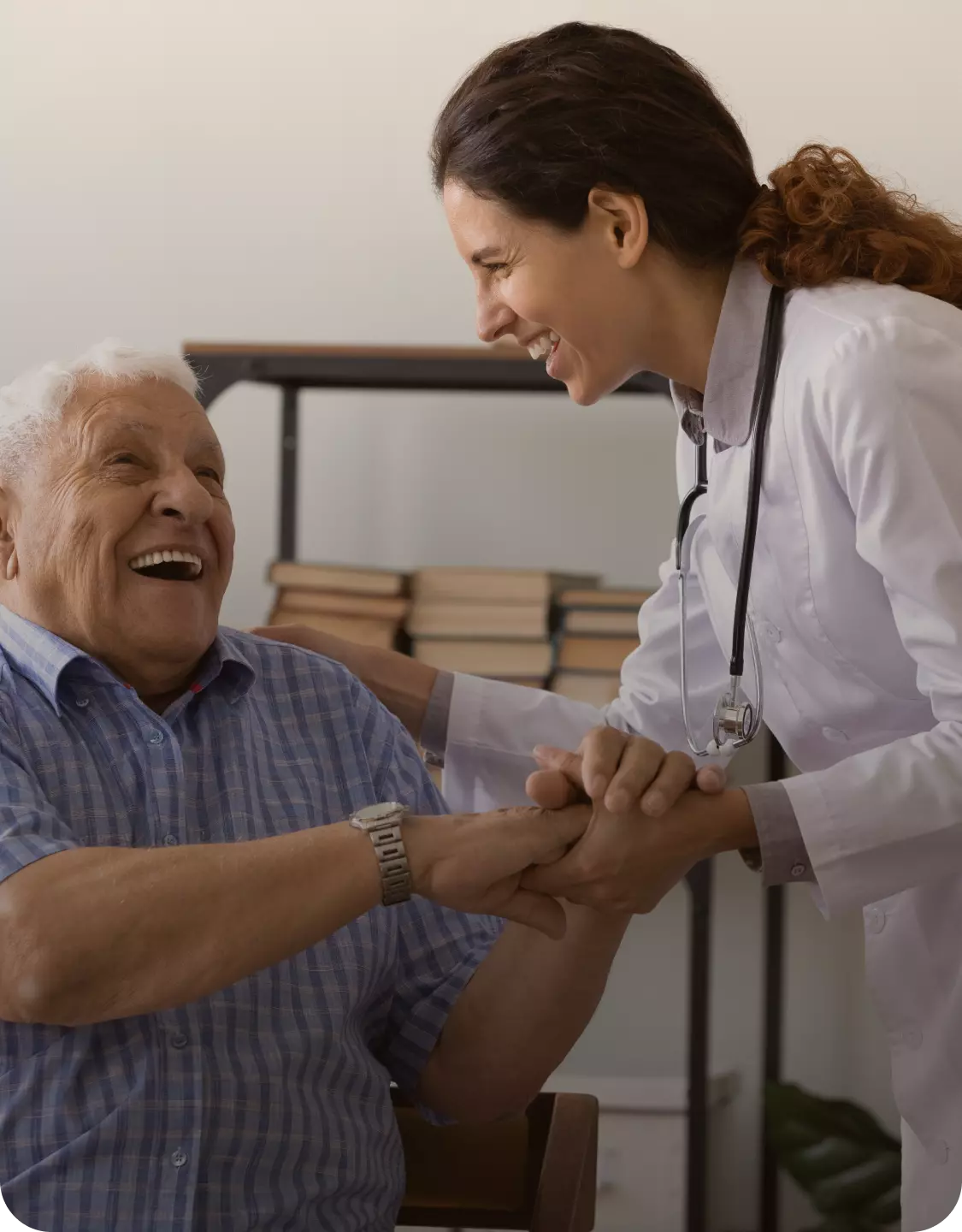 médica sorrindo de mãos dadas com um paciente idoso
